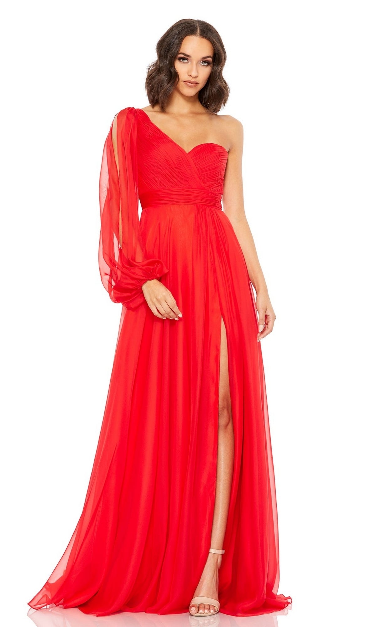 A woman wears the Mac Duggal 67810 One-Sleeve Long Red Formal Dress with a sheer sleeve, fitted bodice, and high slit—an eye-catching choice for any special occasion.
